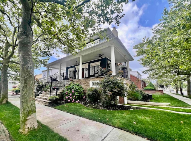 view of front of property featuring covered porch, a front lawn, and ceiling fan