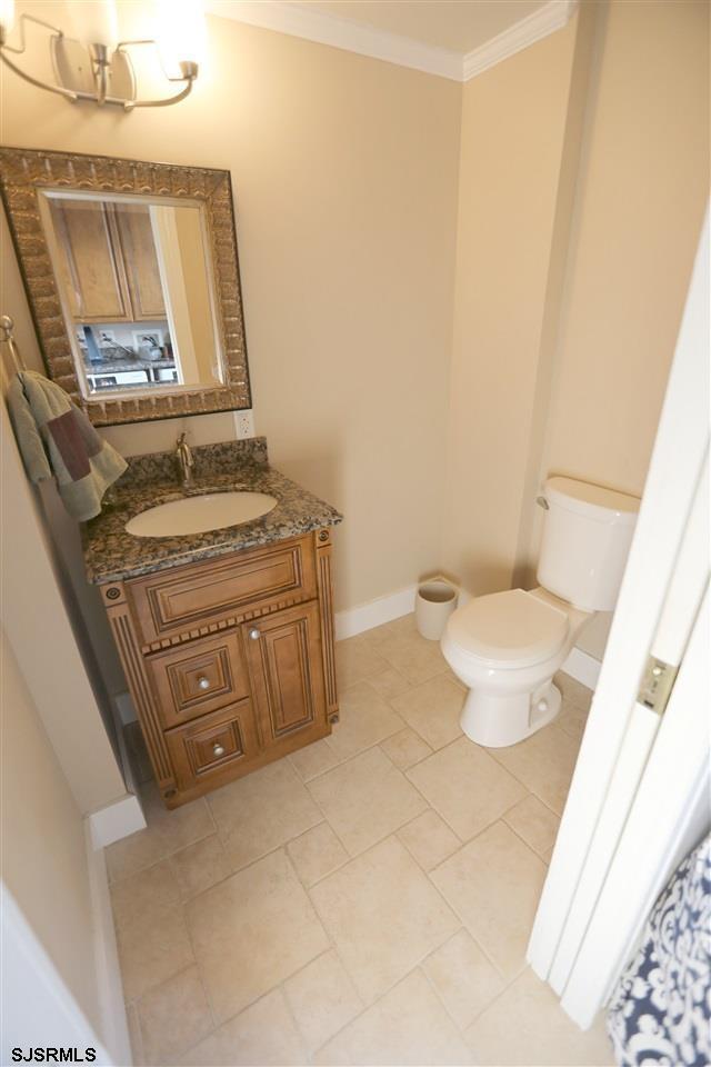 bathroom featuring ornamental molding, tile patterned floors, vanity, and toilet