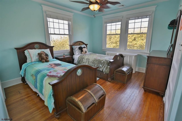 bedroom with ornamental molding, hardwood / wood-style flooring, and ceiling fan