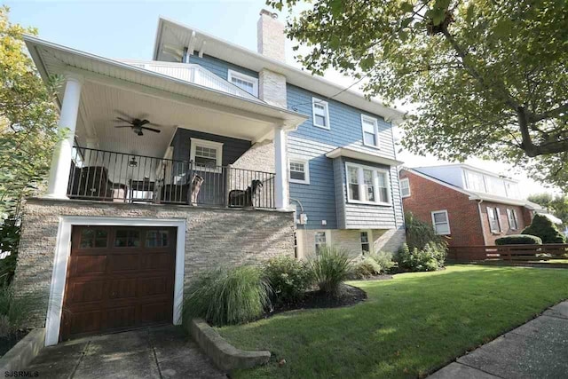 view of front of home featuring ceiling fan, a garage, a front lawn, and a balcony