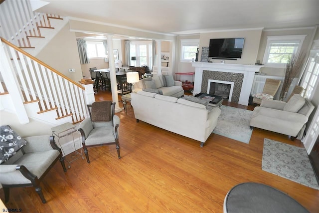 living room with crown molding, hardwood / wood-style floors, and a tile fireplace