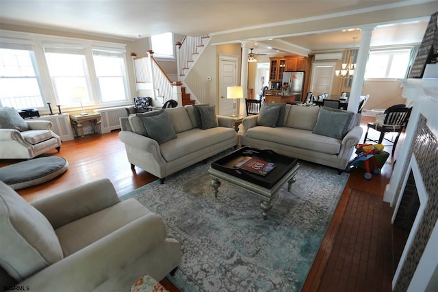 living room featuring crown molding, light hardwood / wood-style flooring, and a healthy amount of sunlight