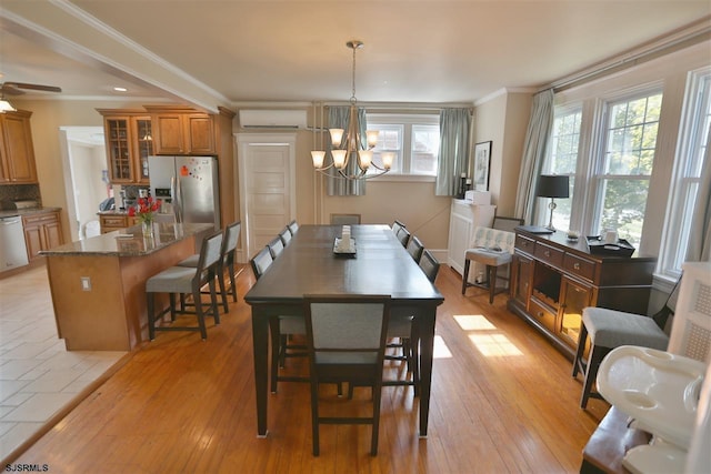 dining room with ceiling fan with notable chandelier, crown molding, a wall mounted air conditioner, and light hardwood / wood-style flooring