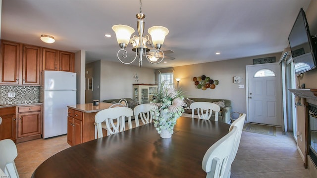 tiled dining room with a notable chandelier