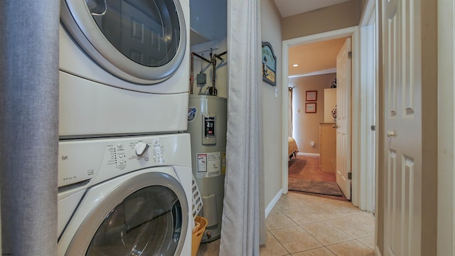 washroom with crown molding, stacked washer and dryer, water heater, and light tile patterned floors