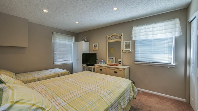 carpeted bedroom with a textured ceiling and a closet