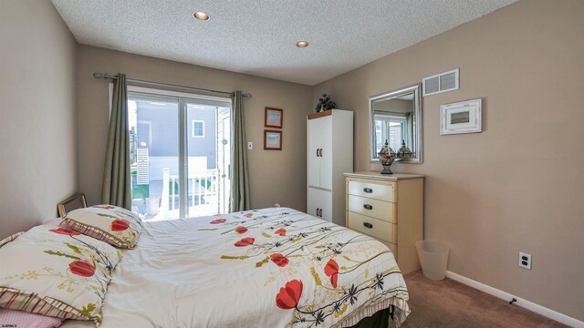 bedroom with a textured ceiling, access to exterior, and carpet