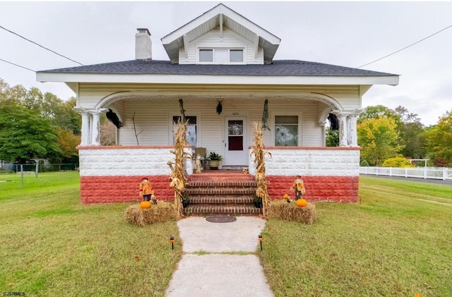 view of front of home with covered porch and a front yard