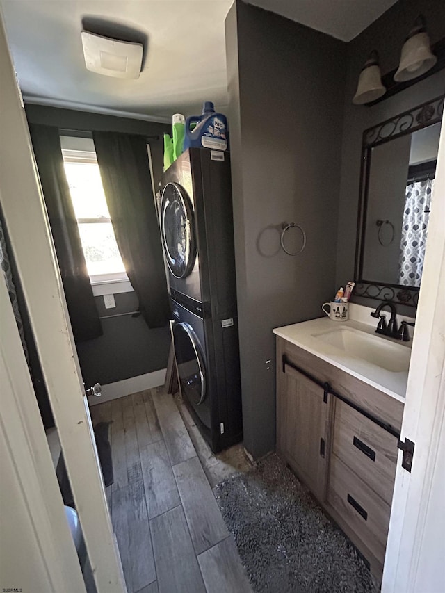 bathroom featuring vanity, stacked washer / drying machine, and hardwood / wood-style floors