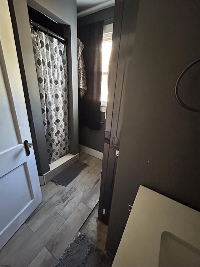 bathroom with walk in shower and wood-type flooring