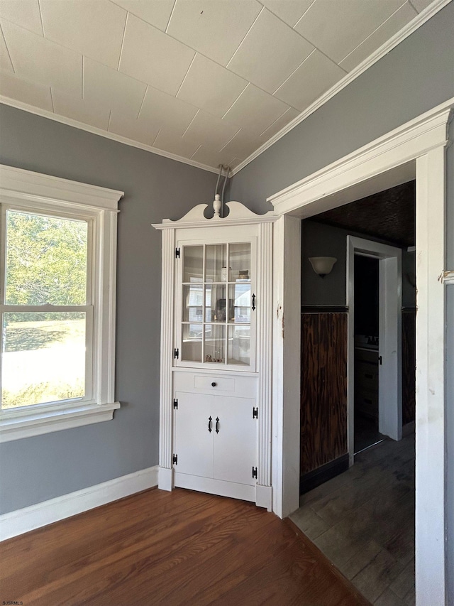 interior space with ornamental molding and dark hardwood / wood-style flooring