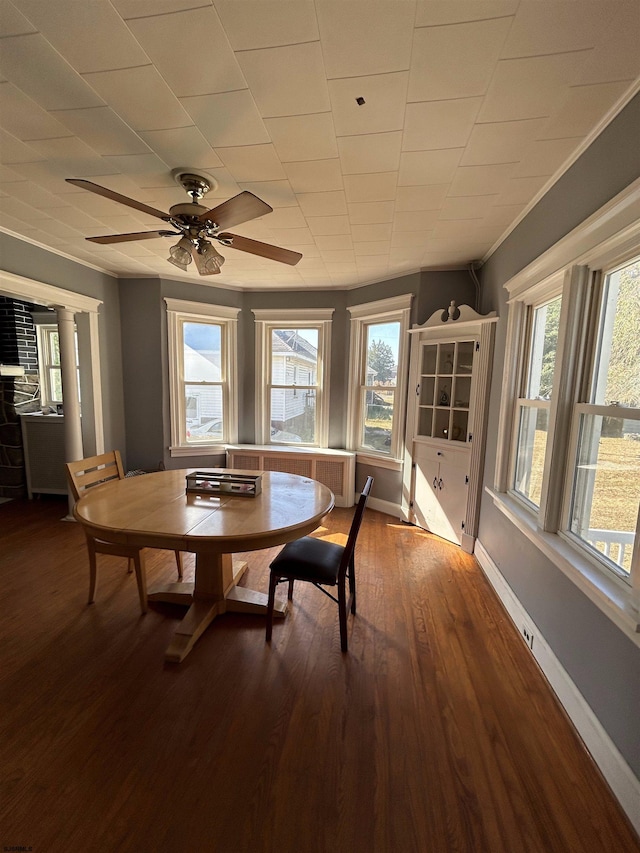 dining space with ceiling fan, plenty of natural light, dark wood-type flooring, and ornamental molding