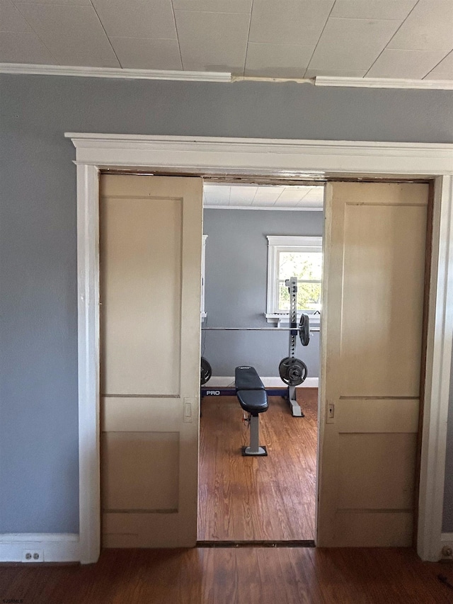 workout area with ornamental molding and hardwood / wood-style flooring