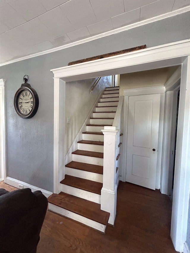 stairs featuring crown molding and hardwood / wood-style flooring