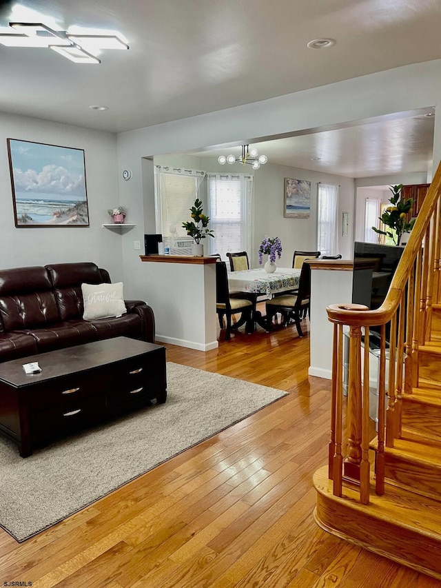 living room with light wood-type flooring and a notable chandelier