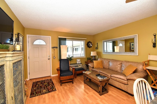 living room with light hardwood / wood-style flooring and a textured ceiling