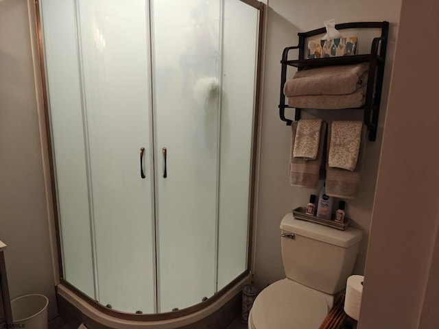 bathroom featuring walk in shower and toilet