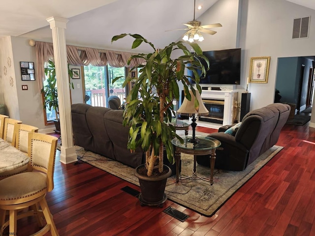 living room featuring ceiling fan, dark hardwood / wood-style floors, ornate columns, and high vaulted ceiling