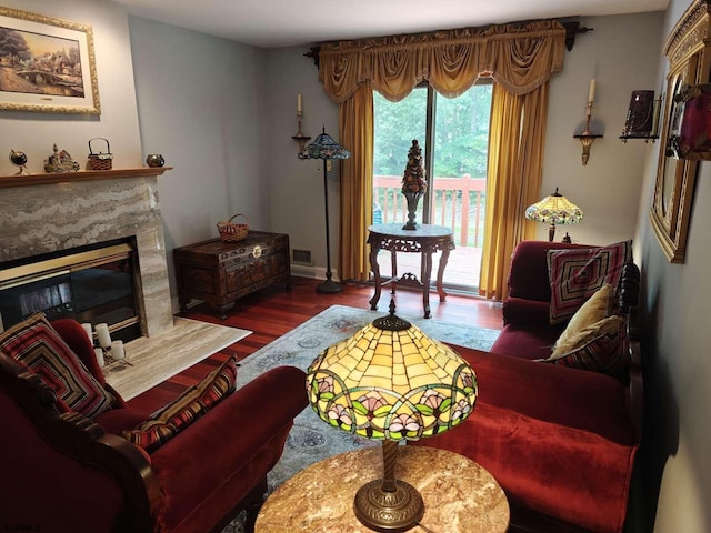 living room with hardwood / wood-style flooring and a high end fireplace