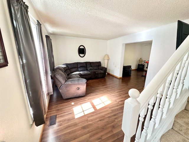 living room with dark hardwood / wood-style flooring and a textured ceiling