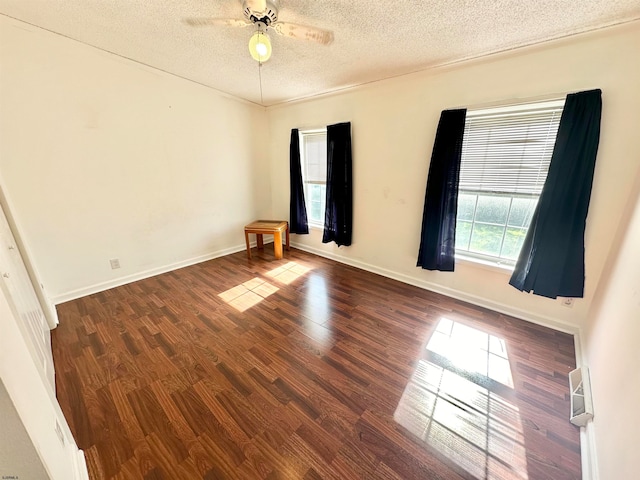 spare room with a textured ceiling, dark hardwood / wood-style flooring, and ceiling fan