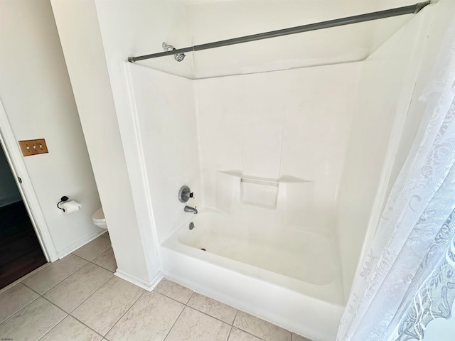 bathroom featuring toilet, shower / tub combo, and tile patterned floors