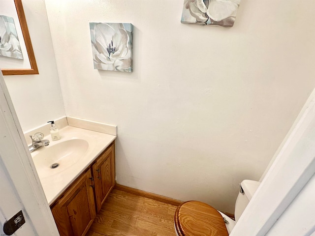 bathroom with vanity, hardwood / wood-style flooring, and toilet