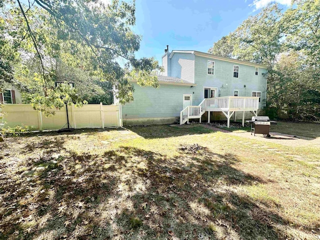 rear view of property with a lawn and a deck