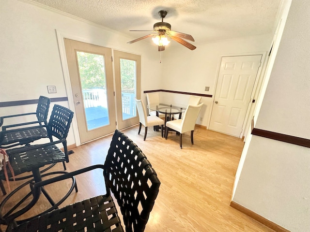 dining space with a textured ceiling, light wood-type flooring, and ceiling fan