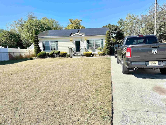 view of front facade with solar panels and a front lawn