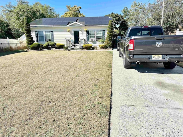 ranch-style house with a front yard and solar panels