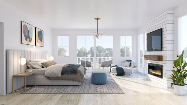 bedroom featuring a fireplace, an inviting chandelier, and wood-type flooring