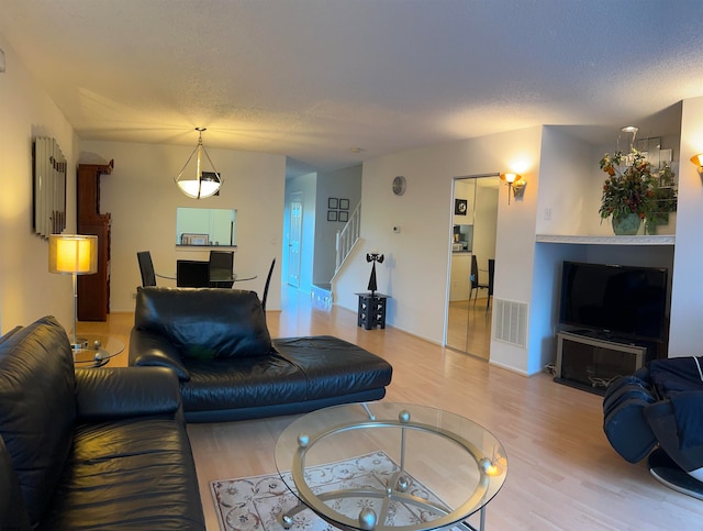 living room featuring a textured ceiling and light hardwood / wood-style flooring