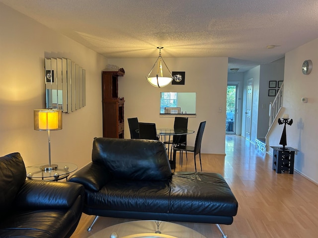 living room with a textured ceiling and hardwood / wood-style floors