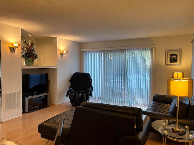 living room with hardwood / wood-style flooring and a textured ceiling