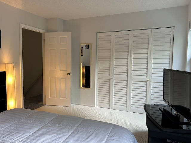 carpeted bedroom featuring a closet and a textured ceiling