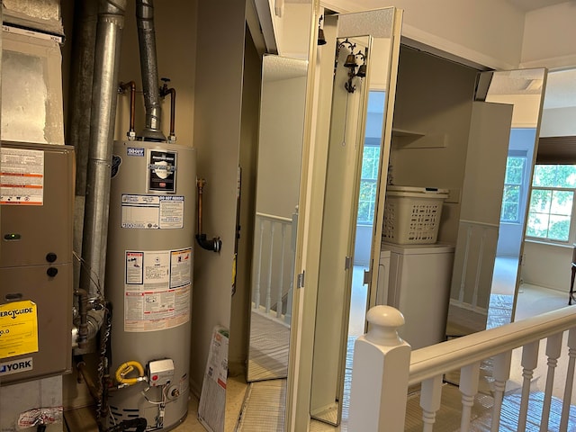 utility room with gas water heater and washer / dryer