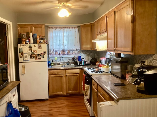 kitchen featuring ceiling fan, light hardwood / wood-style flooring, sink, decorative backsplash, and appliances with stainless steel finishes