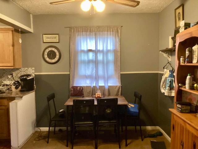 dining room with ceiling fan, a textured ceiling, and radiator heating unit