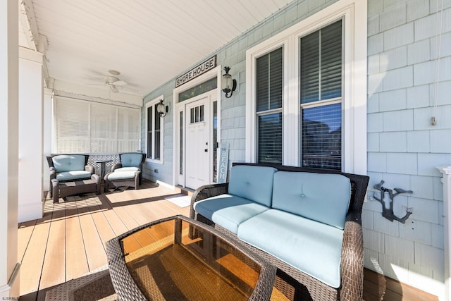 wooden deck with a porch, outdoor lounge area, and ceiling fan