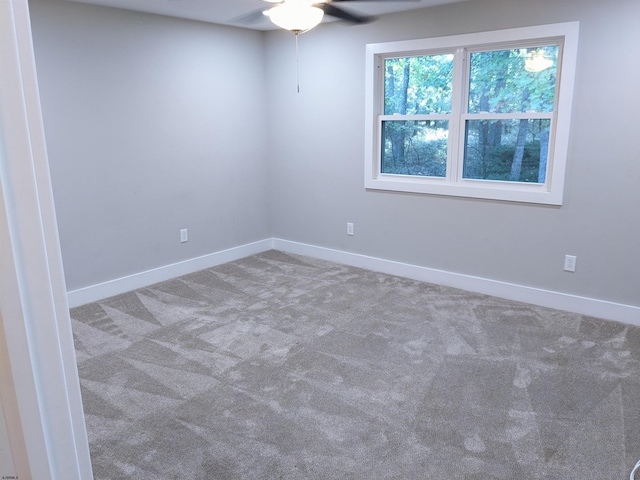 carpeted spare room featuring ceiling fan