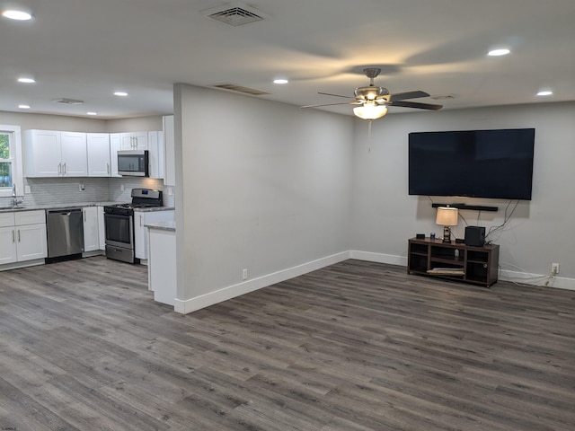 unfurnished living room featuring dark hardwood / wood-style floors, sink, and ceiling fan