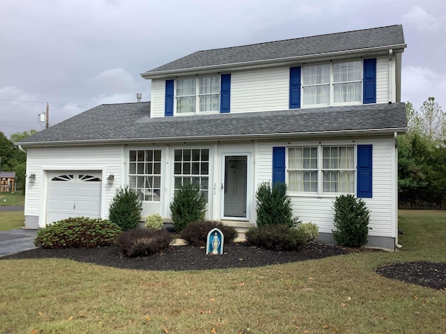 view of property featuring a front lawn and a garage