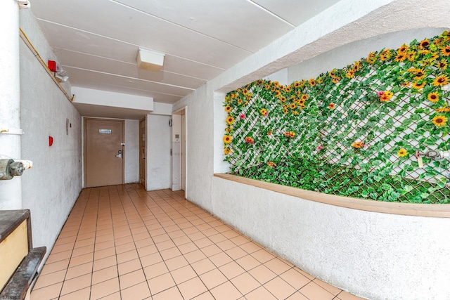 hall with tile patterned floors