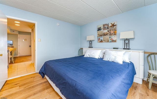 bedroom featuring a textured ceiling and light hardwood / wood-style floors