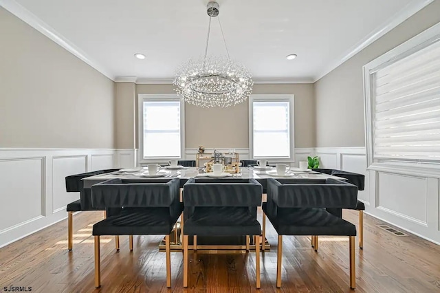 dining area with ornamental molding, plenty of natural light, and wood-type flooring