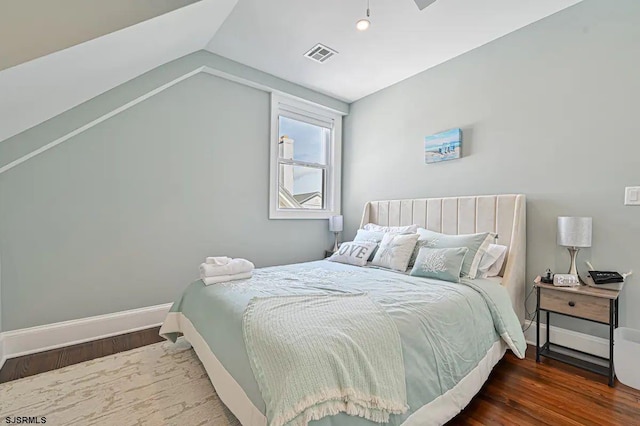 bedroom featuring vaulted ceiling and dark hardwood / wood-style flooring