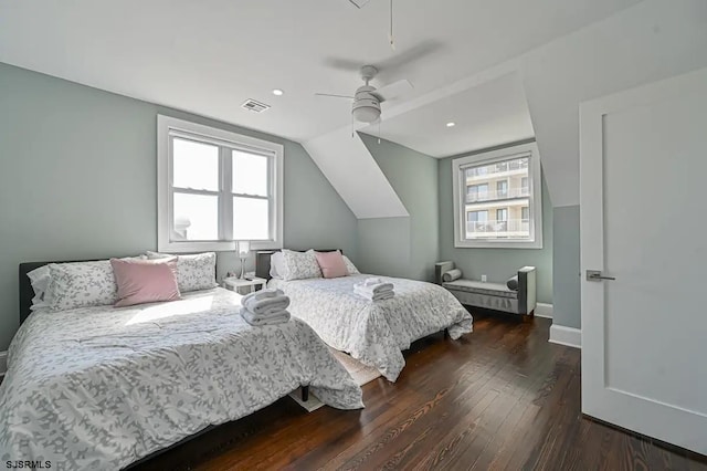 bedroom featuring ceiling fan, dark wood-type flooring, and multiple windows