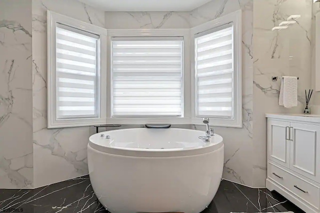 bathroom featuring a washtub and vanity