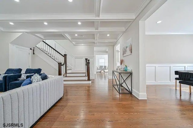 interior space with ornamental molding, coffered ceiling, beam ceiling, and wood-type flooring